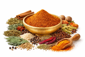 GreatMiller meat masala powder in brass bowl with dried mint, curry leaves, coriander leaves, and whole spices on white background