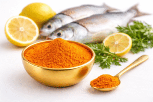 Great Miller fish masala powder in premium golden marble bowl with spoon and fresh fish ingredients on white background